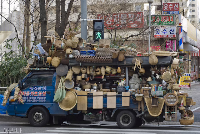 A large truck carries many different straw and bamboo tools. One can see traditional shoes, hats, a "Dutch wife" to help keep one cool while sleeping in the summer, and bamboo cutting boards.