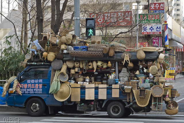A large truck carries many different straw and bamboo tools. One can see traditional shoes, hats, a "Dutch wife" to help keep one cool while sleeping in the summer, and bamboo cutting boards.
