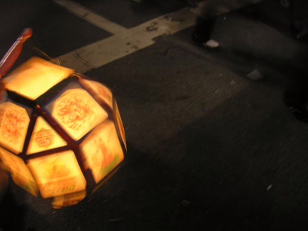 A brightly lit lantern hangs from a stick at Buddha's Birthday Parade in Seoul South Korea, May 2007.