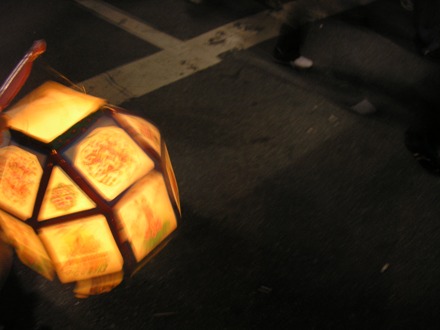 A brightly lit lantern hangs from a stick at Buddha's Birthday Parade in Seoul South Korea, May 2007.