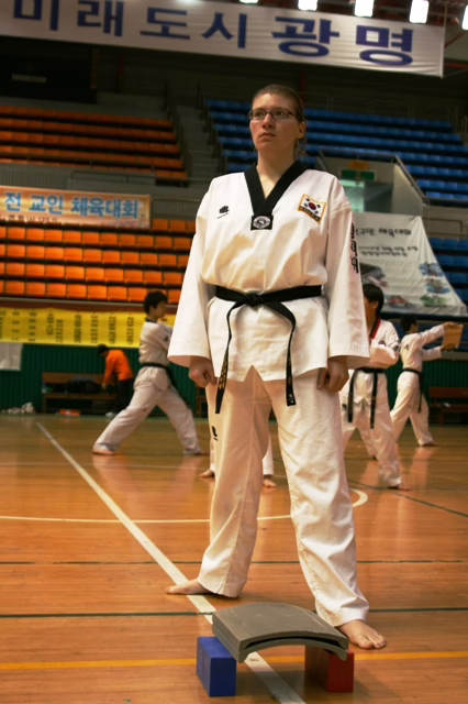 I stand in my taekwondo uniform in front of two roofing tiles, which I'll break at a taekwondo exhibition in Gwangmyeong, South Korea, 2007