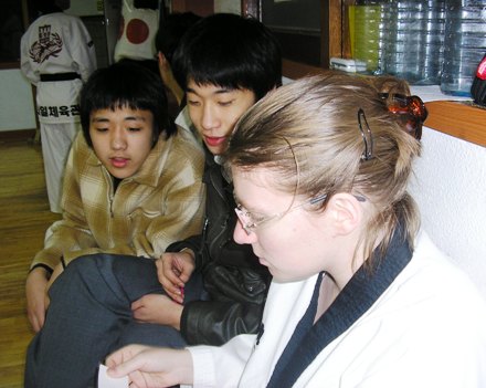 I study Korean flashcards while two high school boys at the taewkdono studio look on and help.