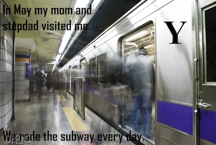 Smeared shapes of people are seen getting onto a subway car. The subway is still. The letter Y is on this photo.